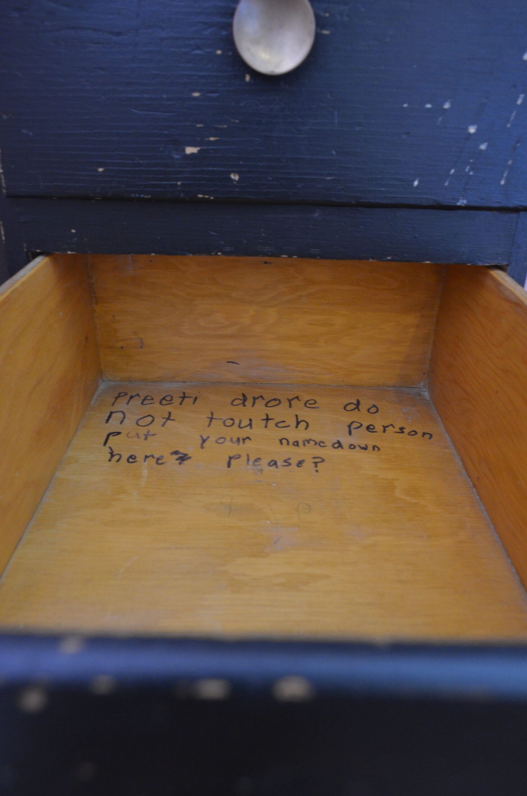 Photo of the author's childhood handwritten message in the desk drawer.